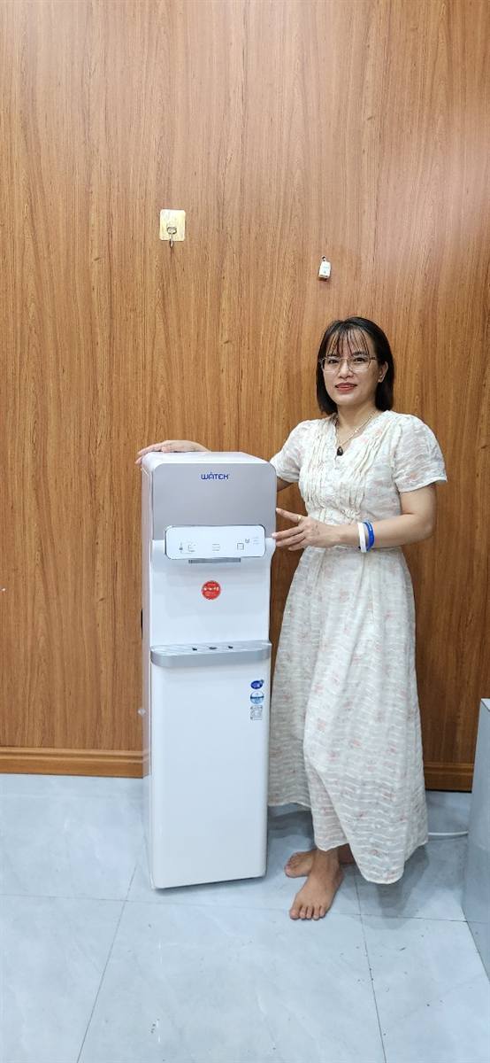 Hồng Nhung bên máy lọc nước nóng lạnh